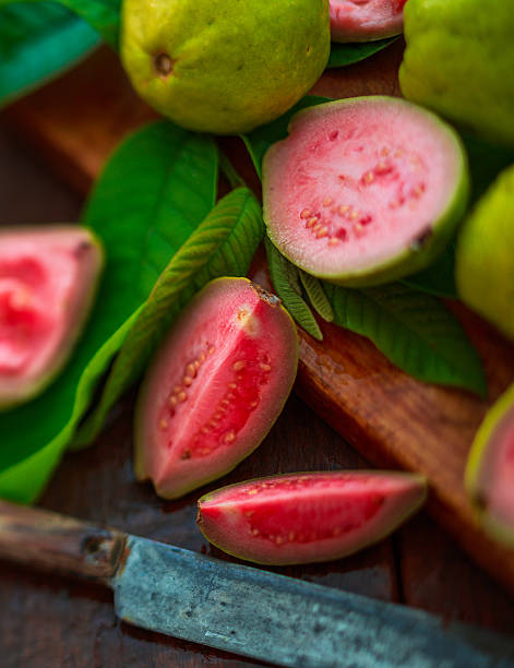 guava fruits ripe guava fruits on a vintage metal plate and knife guava photos stock pictures, royalty-free photos & images