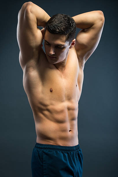 молодой спортивный человек над серый фон - sex symbol the human body male abdomen стоковые фото и изображения