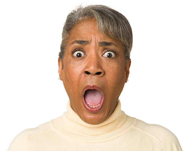 Terrified Gasping Mature Woman Portrait of a mature woman on a white background. frowning headshot close up studio shot stock pictures, royalty-free photos & images