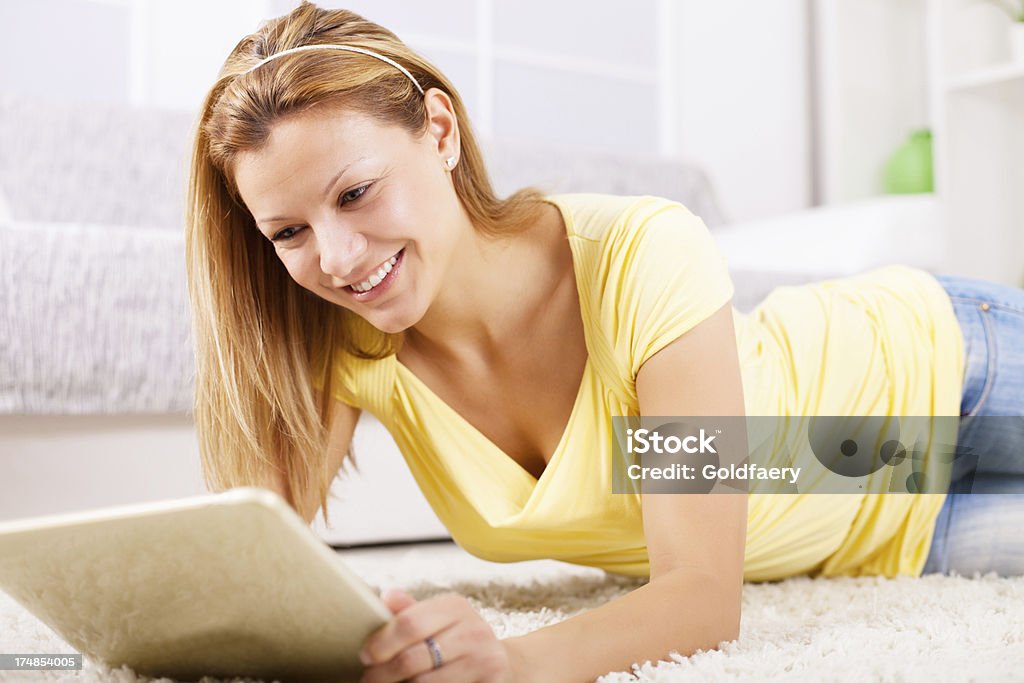 Piękne blonde kobieta przy użyciu komputera typu tablet w domu. - Zbiór zdjęć royalty-free (30-39 lat)