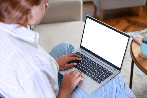 istock Cropped image of woman using laptop with blank white screen at home 1748543219