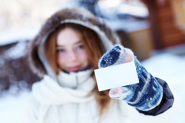 el invierno. chica con tarjeta de visita en blanco - invitation blank smiling business card fotografías e imágenes de stock