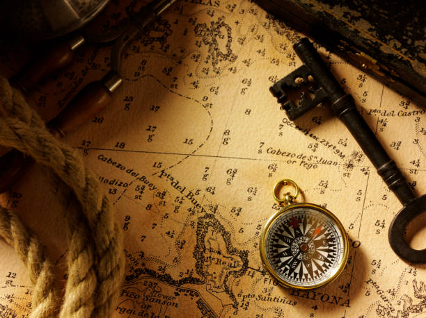bússola e chave sobre um velho mapa do tesouro - the way forward compass rose map key imagens e fotografias de stock