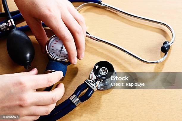 Hands Holding The Dial Of A Blood Pressure Gauge Stock Photo - Download Image Now - Blood Pressure Gauge, Color Image, Cuff - Sleeve