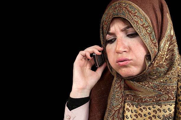 musulmans femme parlant sur téléphone mobile - middle eastern ethnicity teenage girls women sadness photos et images de collection