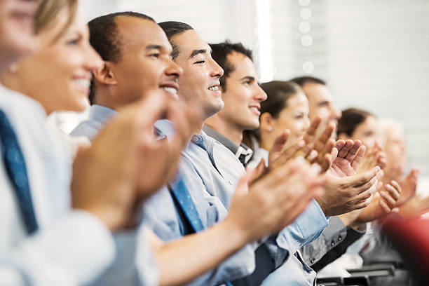 groupe d'hommes d'affaires assis dans une ligne applaudir. - business meeting smiling ethnic multi ethnic group photos et images de collection