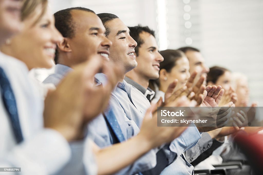 Grupo de empresários sentado em uma linha e a aplaudir. - Foto de stock de Seminário - Reunião royalty-free