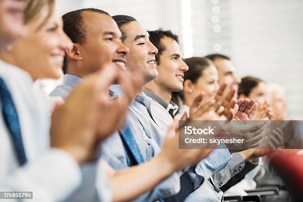 Foto de Grupo De Empresários Sentado Em Uma Linha E A Aplaudir e mais fotos de stock de Seminário - Reunião