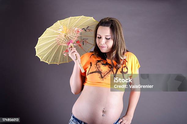 Młoda Kobieta W Ciąży Na Szarym Z Parasolka Przeciwsłoneczna - zdjęcia stockowe i więcej obrazów 20-29 lat
