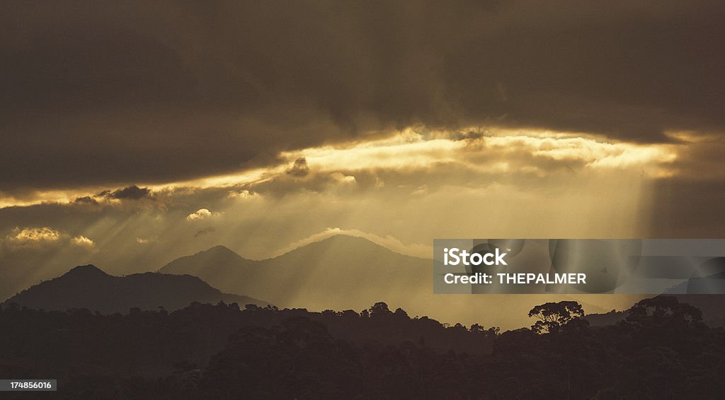 sun rays over the mountains in honduras sun rays early in the morning over the jungle and mountains behind the airport of la ceiba  in honduras, central america Cloud - Sky Stock Photo