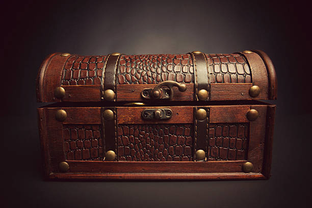 istock gold coins peeking through treasure chest 174856028