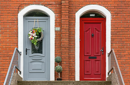 Dublin, Ireland - August 3, 2023: Two typical side-by-side elegant house front doors at the top of a staircase