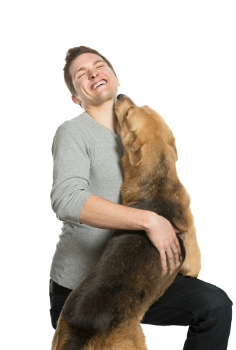 Young man laughing while his dog embraces him.A selection of related photographs: