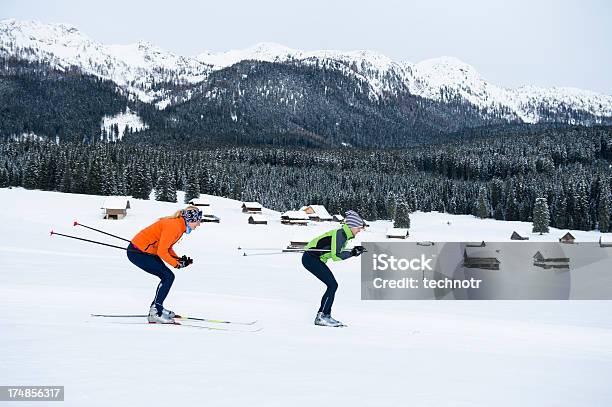 Young Couple At Cross Country Skiing Downhill Stock Photo - Download Image Now - Cross-Country Skiing, Side View, Young Men