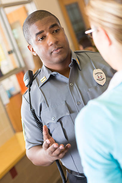 istock Police officer talking to a teacher on campus 174856428
