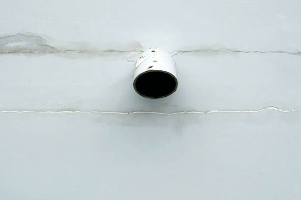 A plastic pipe hole on the white wall of the building for texture and backgrounds.