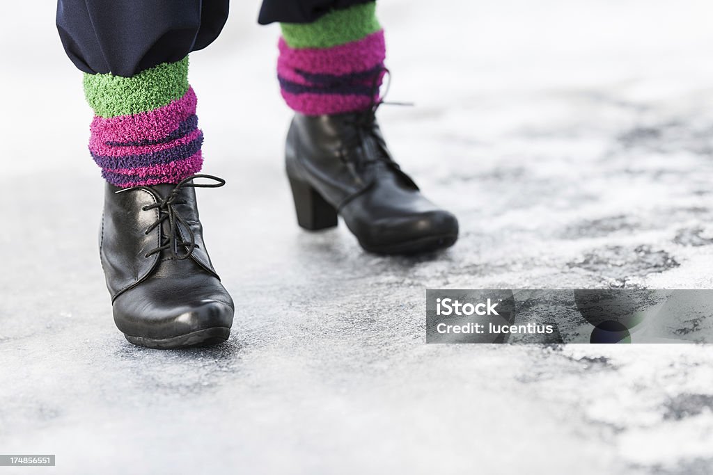 Slippery ice Low angle close-up with copy space of a woman's feet walking on hazardous slippery ice on a sidewalk. Adult Stock Photo