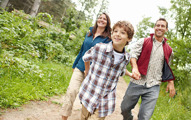 istock A young boy leading a man and woman down a trail 174856627