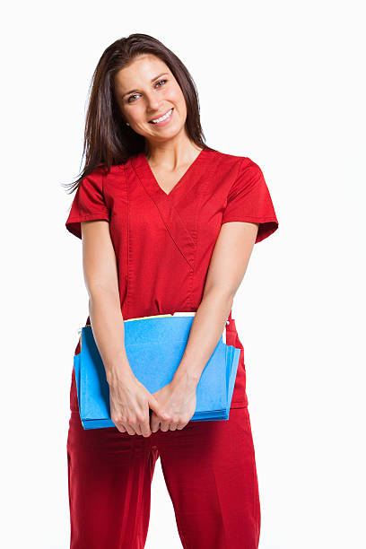 Nurse Young nurse wearing scrubs, holding patient files. red medical scrubs stock pictures, royalty-free photos & images