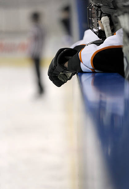 istock Young hockey player waiting on the bench 174857543