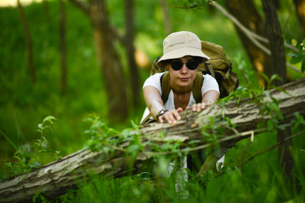 young mountaineer lady hiking in the forest and making a campfire