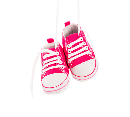 Hanging Girl Baby shoes in pink isolated on white