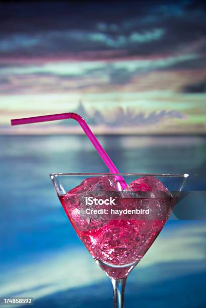Cocktail With Pink Straw Against Beach And Sunset Background Stock Photo - Download Image Now