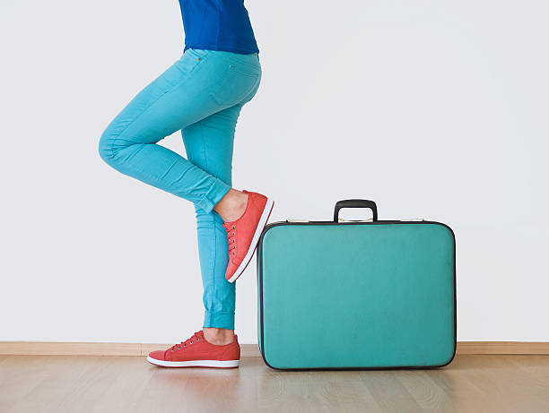 istock Young woman stands beside suitcase 174858858