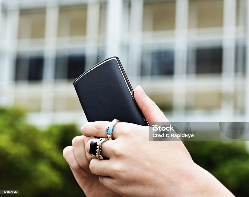 Weibliche hand mit Smartphone vor Bürogebäude - Lizenzfrei Am Telefon Stock-Foto