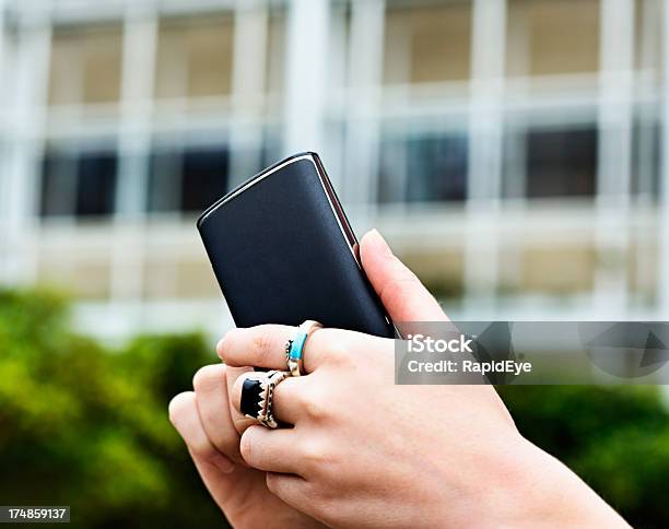 Foto de Feminino Mão Usando Telefone Inteligente No Lado De Fora Do Edifício De Escritório e mais fotos de stock de Anel - Joia