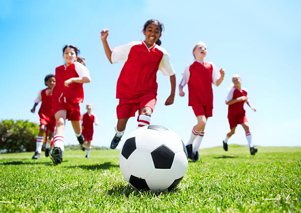 Two happy children preparing to play soccer in the backyard. Having fun during covid-19. Social distancing.