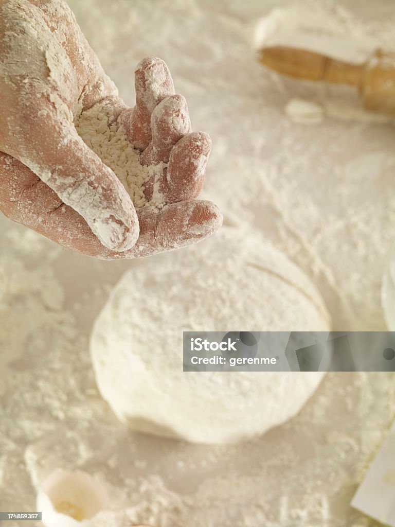 Sprinkling Flour on Dough Man sprinkling flour on dough. Adults Only Stock Photo