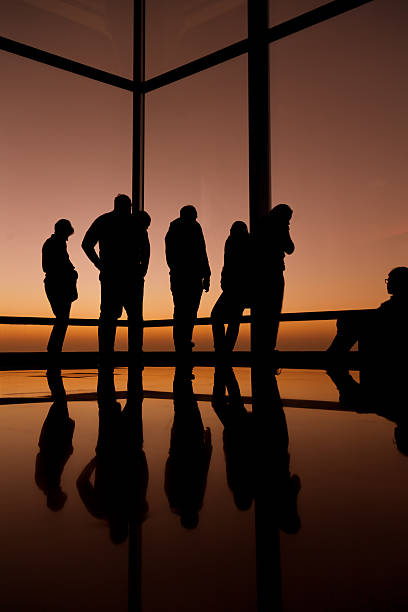 gruppo di persone guardare fuori dalla finestra. - office indoors contemporary office building foto e immagini stock