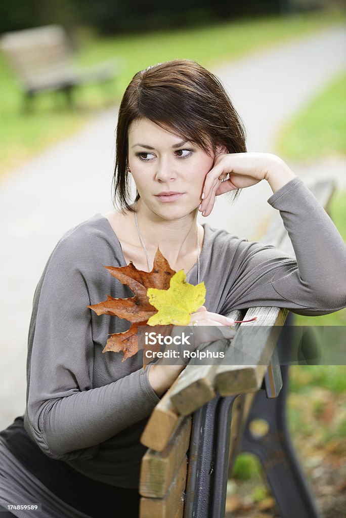 Брюнетка женщина, сидя на парк Скамейка мышление - Стоковые фото 20-24 года роялти-фри