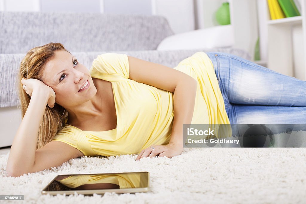 Belle femme blonde allongée sur le tapis comme chez vous. - Photo de Activités de week-end libre de droits