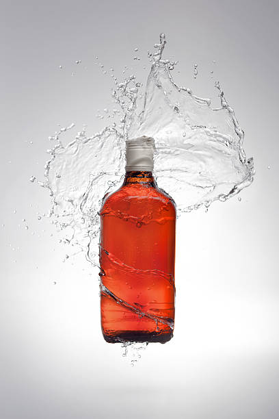 istock Bottle of alcohol with water splash 174860168