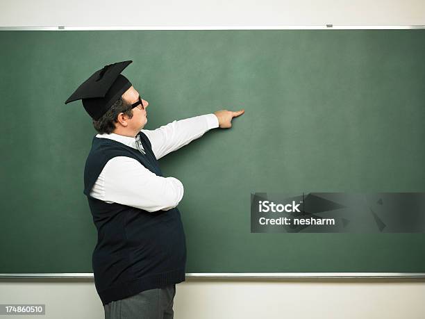 Foto de Homem Nerd Mostrando No Quadronegro e mais fotos de stock de Chapéu de Formatura - Chapéu de Formatura, Homens, Quadro-negro