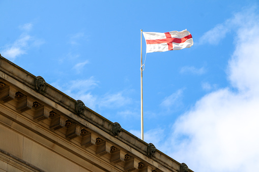 National flag of Georgia waving under blue sky.