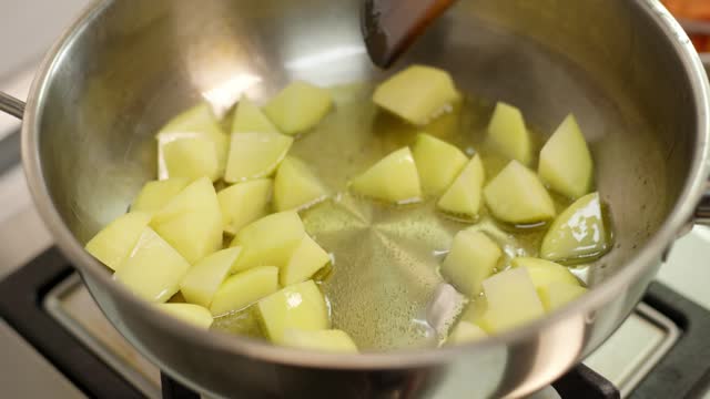 Woman Pan-Frying Potatoes in Skillet - Stock Video Footage