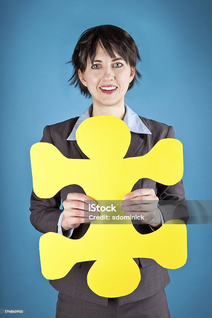 Negocios mujer sostiene amarillo pieza de rompecabezas - Foto de stock de 35-39 años libre de derechos
