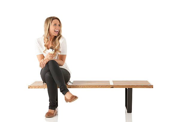 istock Woman sitting on a bench enjoying ice cream 174861101