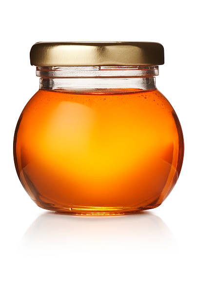 runde jar of pure goldenen honig mit gold deckel - syrup jar sticky isolated objects stock-fotos und bilder