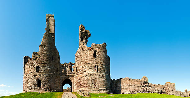 castelo de dunstanburgh, northumberland, reino unido - castle famous place low angle view england - fotografias e filmes do acervo