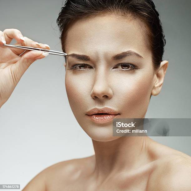 Mujer Joven Puntear Su Con Pinzas De Cejas Foto de stock y más banco de imágenes de 20 a 29 años - 20 a 29 años, Adulto, Adulto joven