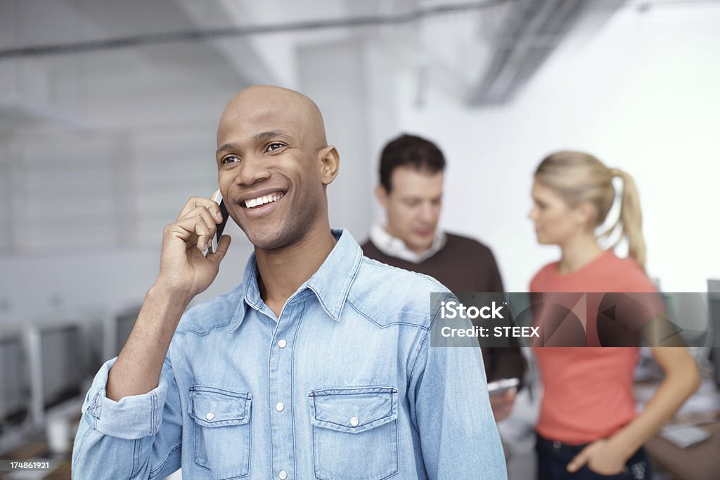 Yes, I'm just following up - Business calls A young businessman talking on his cellphone in the office Adult Stock Photo