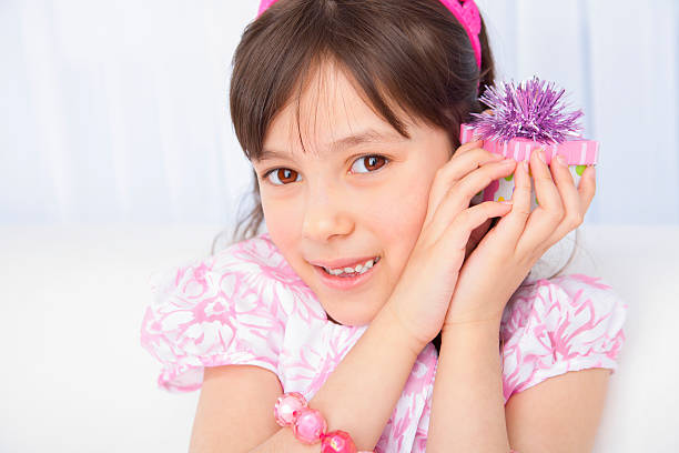 Young 7 year old birthday girl holding a little present
