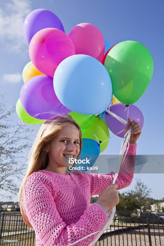 Girl holding balloons Girl (9 years) holding bunch of balloons. 8-9 Years Stock Photo