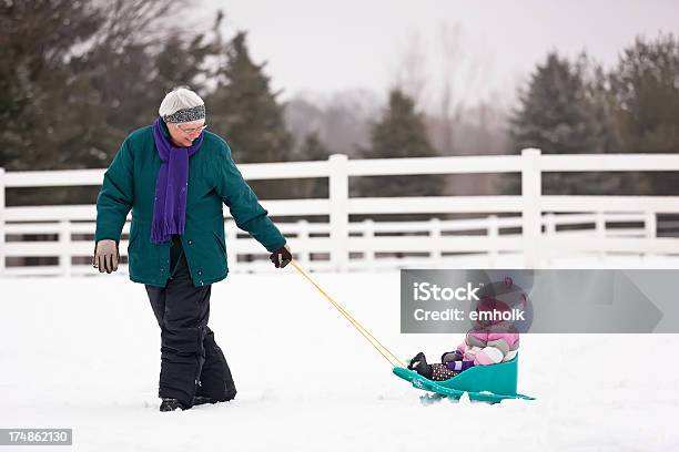 Grandma Pulling Granddaughter In Sled Stock Photo - Download Image Now - Snow, Grandmother, Family