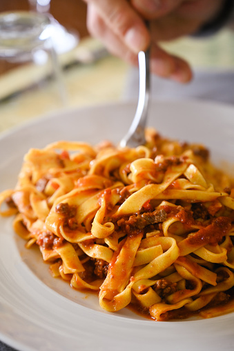 close up of tagliatelle with bolognese sauce in a restaurant.