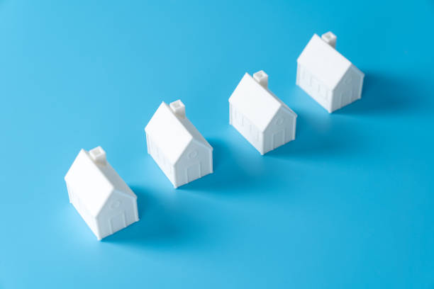 istock Miniature 3D printed model house on blue background 1748622604